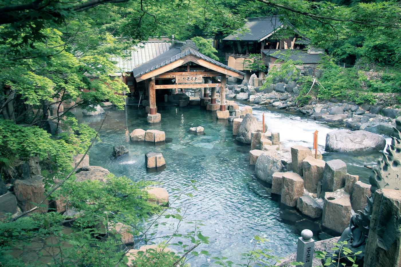 Takaragawa Onsen in gunma, Japan - Japan's largest outdoor mixed-gender hot spring bath along a pristine mountain river, featuring rustic wooden ryokan architecture and therapeutic waters in a remote mountain valley setting.