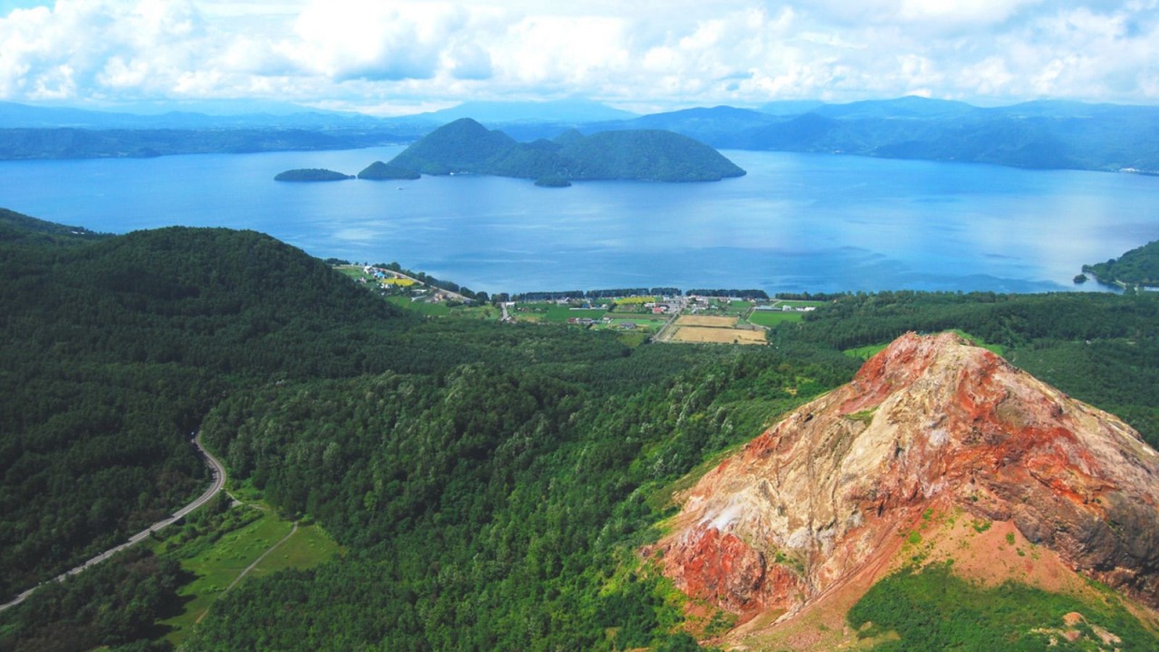 Lake Toya & Mt. Usu in hokkaido, Japan - A stunning volcanic caldera lake paired with an active volcano, offering year-round beauty, onsen resorts, and accessible volcano observation platforms.